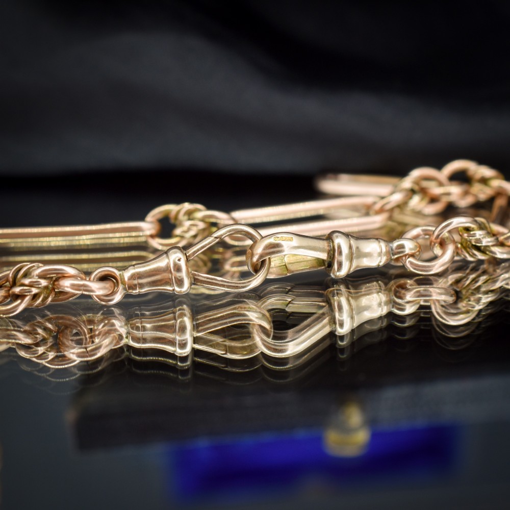 An antique 9ct yellow gold necklace featuring elongated trombone links, twisted love knots, and a central suspended T-bar. View VIII