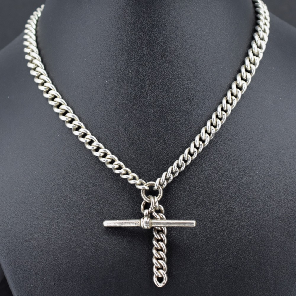 A sterling silver curb link double Albert pocket watch chain featuring a central T-bar.