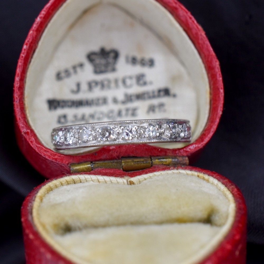 An Art Deco palladium full eternity ring set with a continuous band of round diamonds bordered by milgrain edging. View III