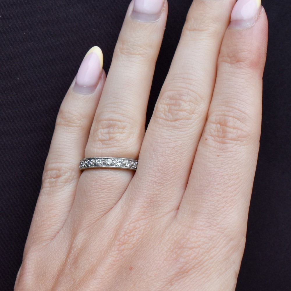 An Art Deco palladium full eternity ring set with a continuous band of round diamonds bordered by milgrain edging. View XI