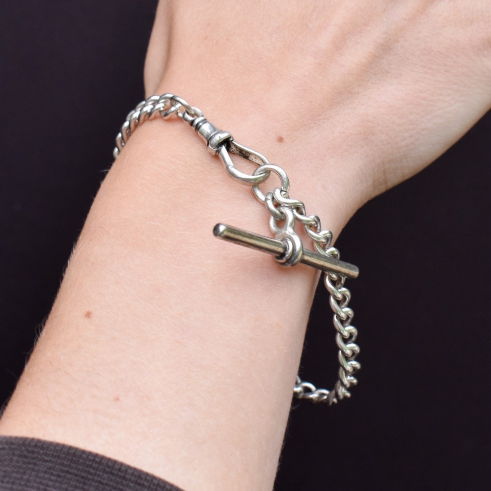 A sterling silver curb link chain bracelet featuring a swivel dog clip fastener and a T-bar pendant. View X