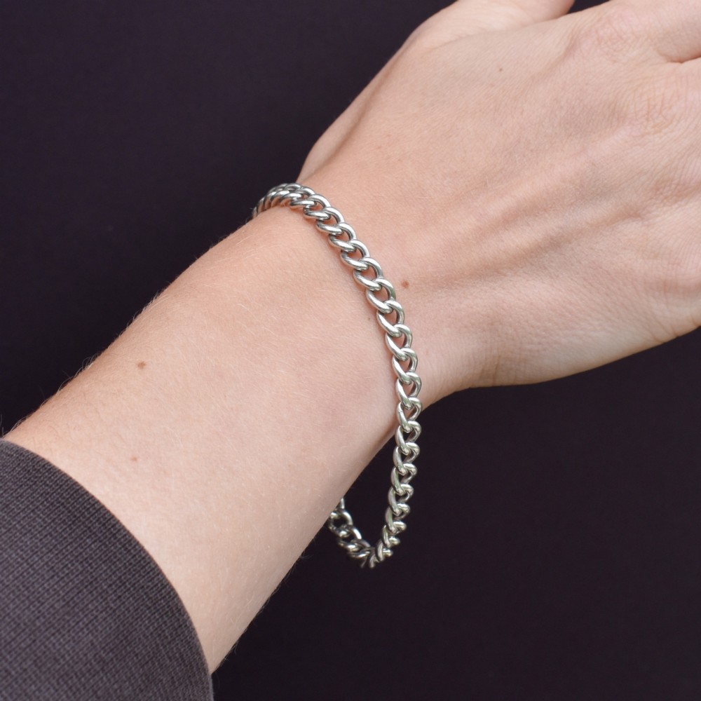A sterling silver curb link chain bracelet featuring a swivel dog clip fastener and a T-bar pendant. View XI