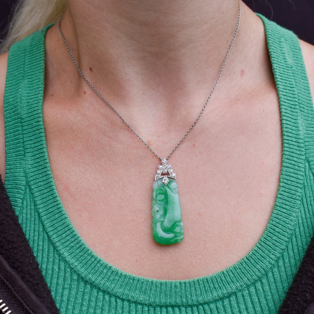 An Art Deco carved green jade pendant with geometric platinum and diamond accents on a chain. View XI
