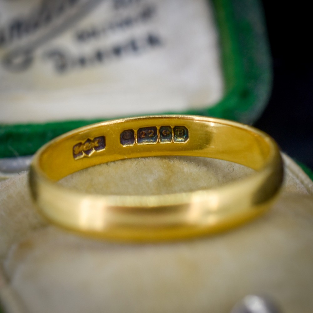 A polished 22ct yellow gold plain wedding band displaying visible interior hallmarks. View III