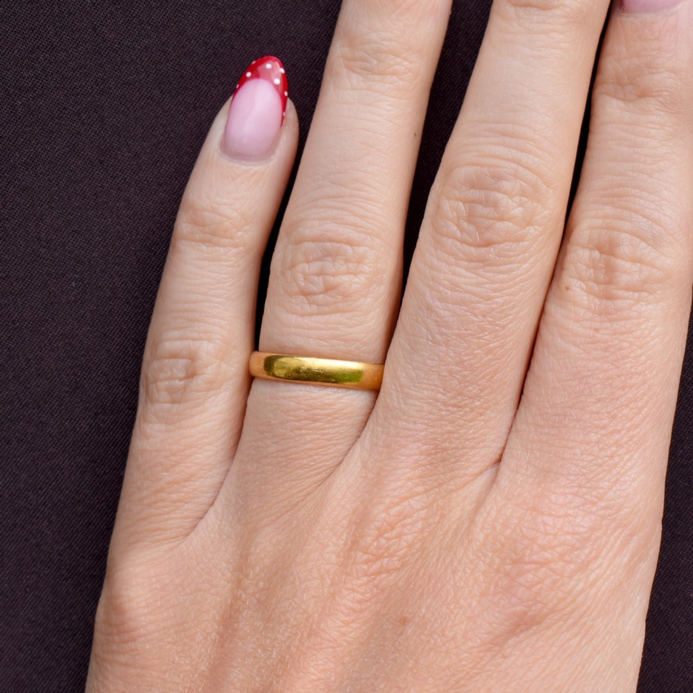 A polished 22ct yellow gold plain wedding band displaying visible interior hallmarks. View VIII