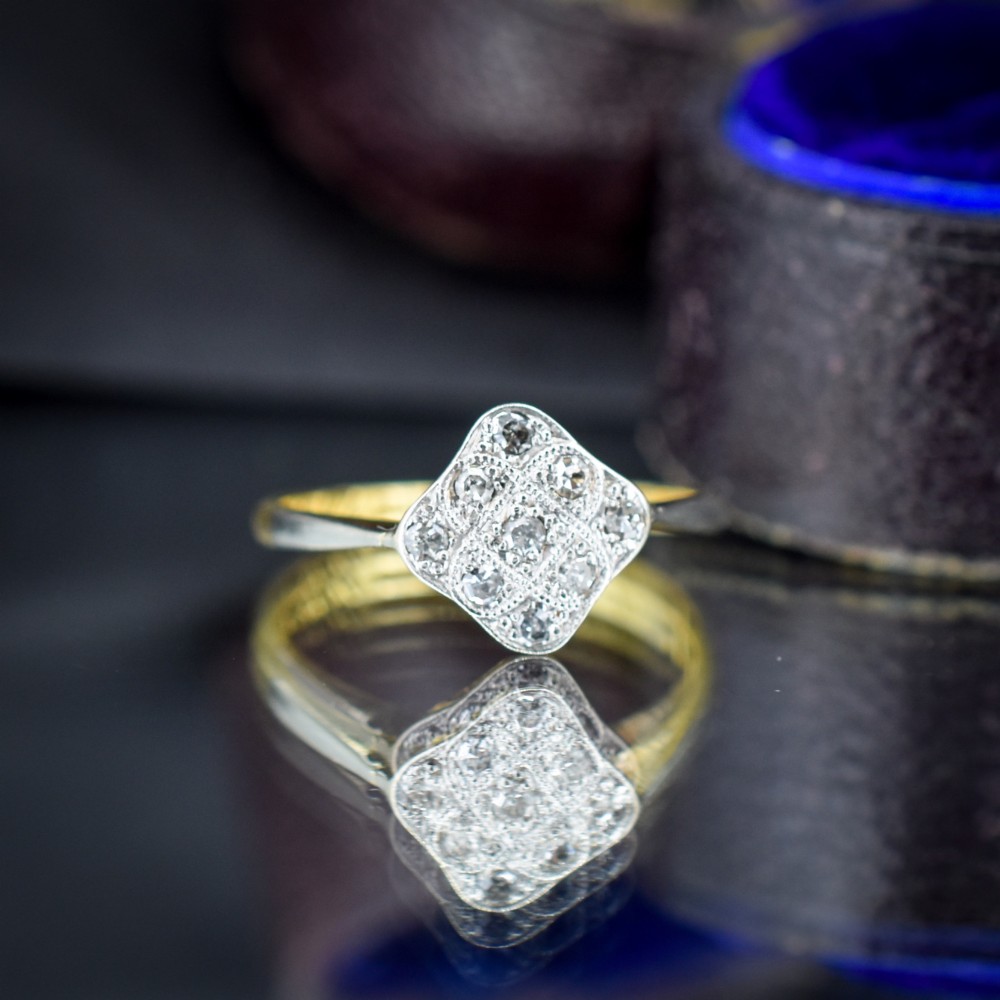 An Art Deco 18ct yellow gold ring featuring a platinum square lozenge cluster set with multiple diamonds and fine millegrain details. View III