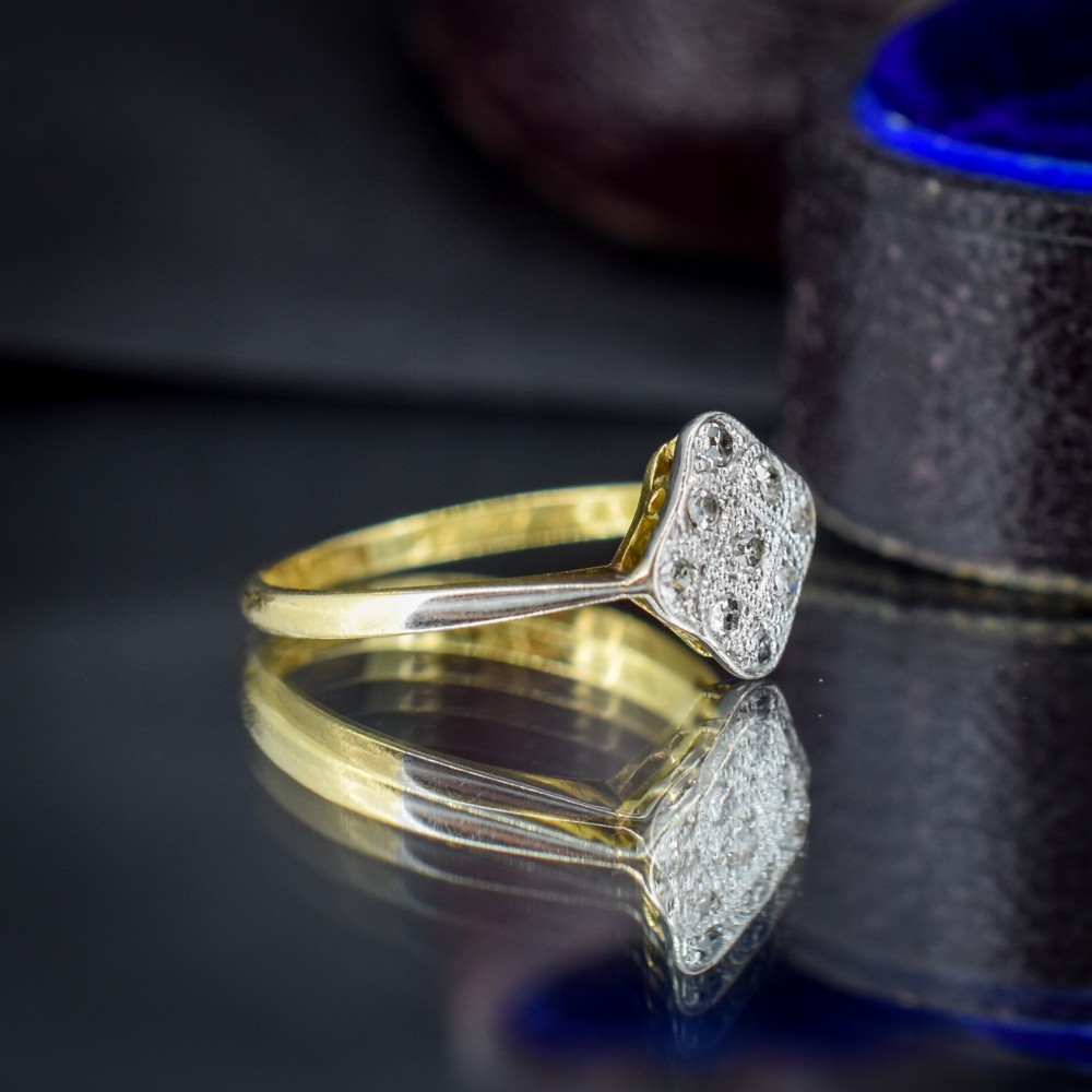 An Art Deco 18ct yellow gold ring featuring a platinum square lozenge cluster set with multiple diamonds and fine millegrain details. View IV