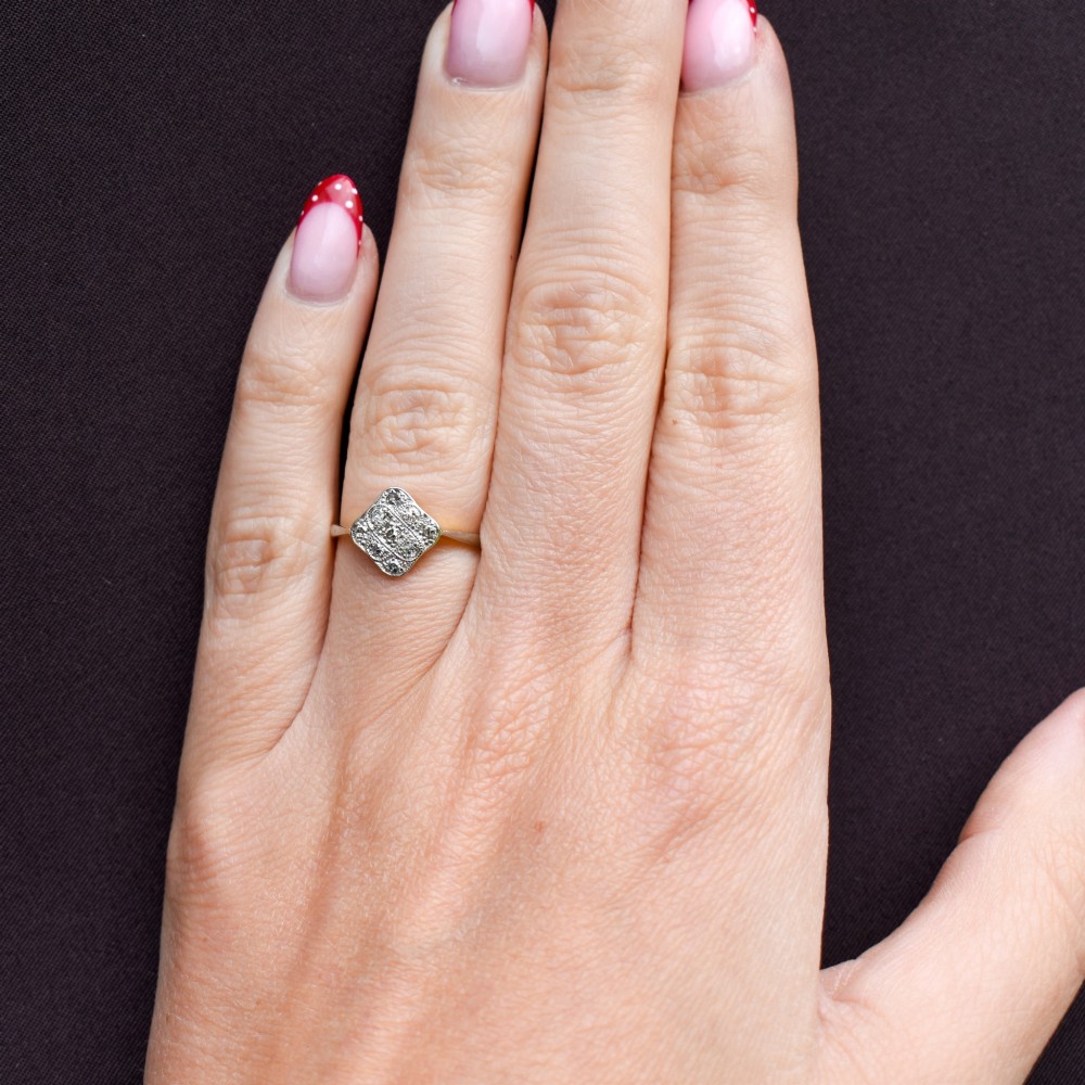 An Art Deco 18ct yellow gold ring featuring a platinum square lozenge cluster set with multiple diamonds and fine millegrain details. View XI