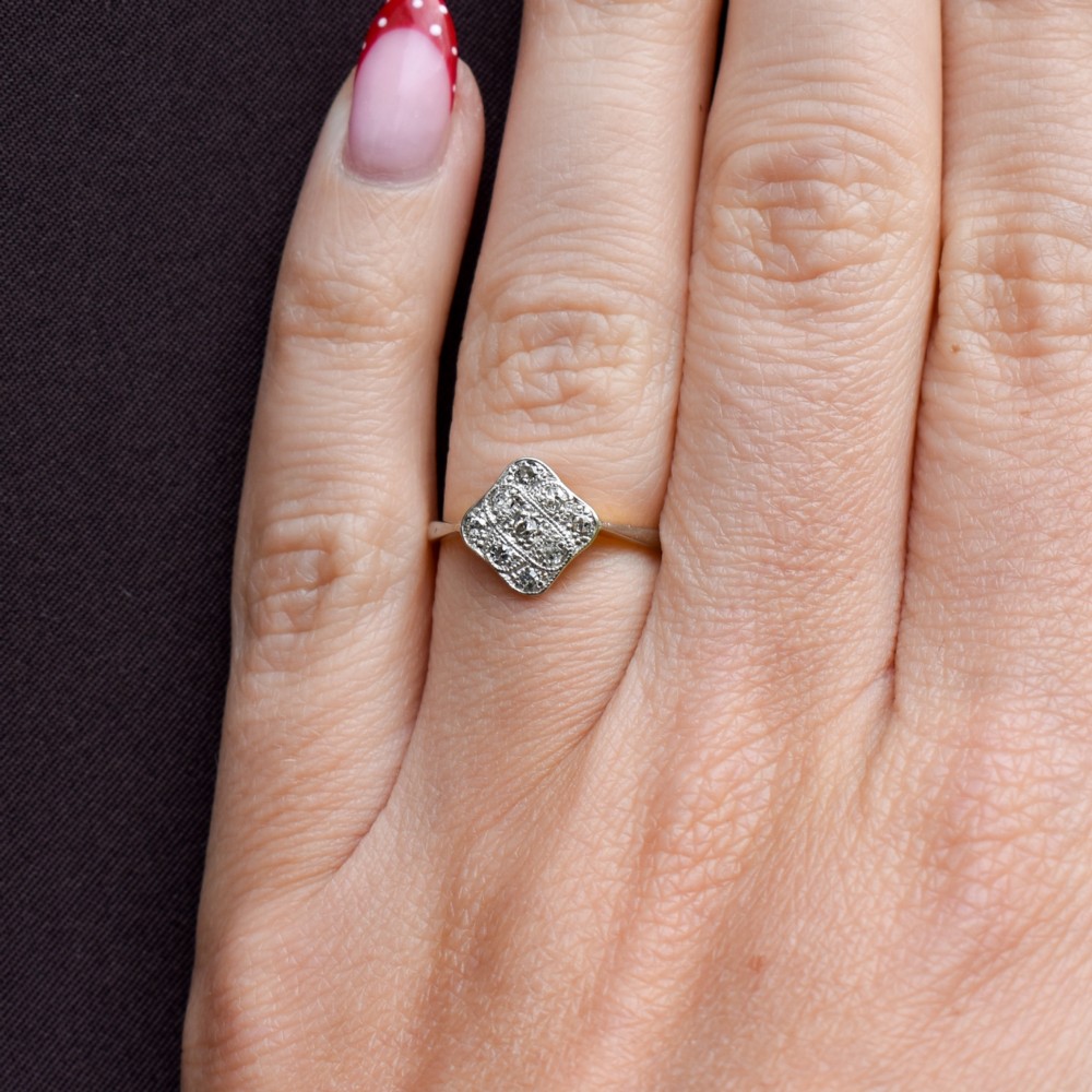An Art Deco 18ct yellow gold ring featuring a platinum square lozenge cluster set with multiple diamonds and fine millegrain details. View XII
