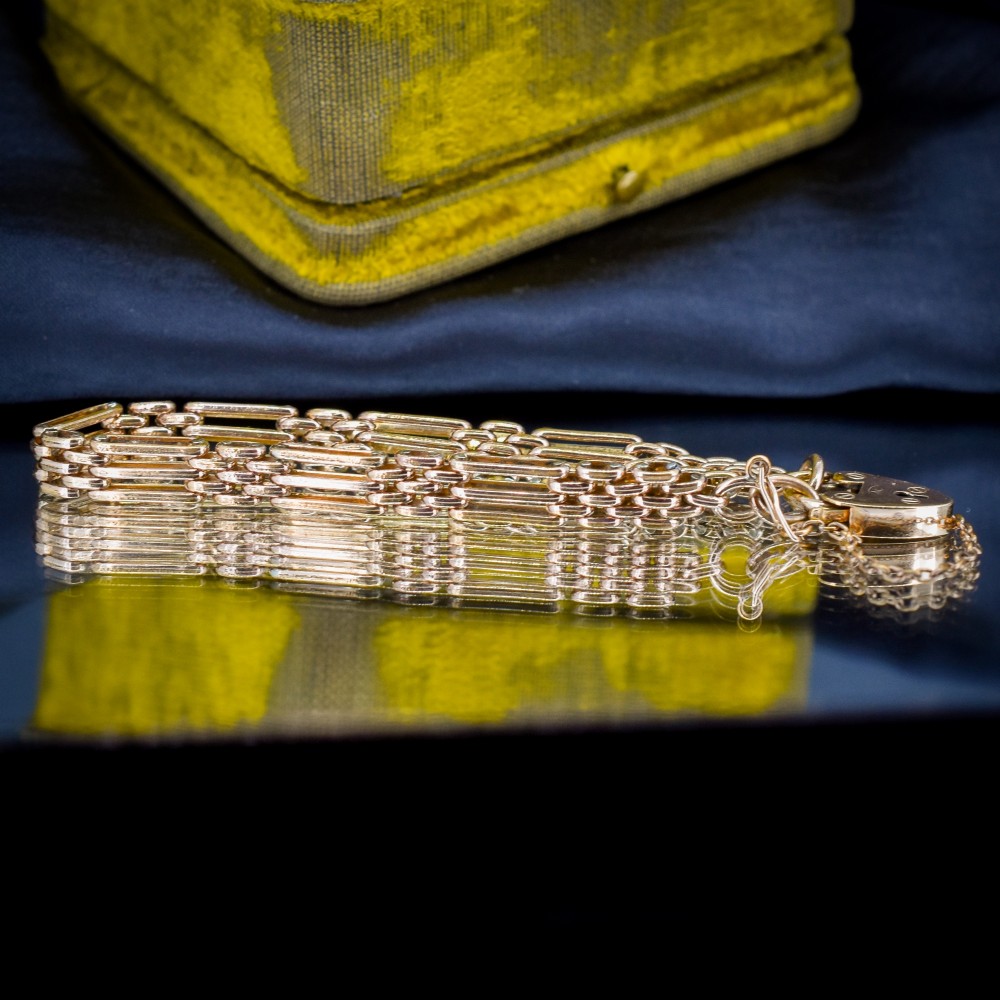 An antique rolled gold gate link bracelet featuring an engraved heart-shaped padlock clasp and safety chain. View IV