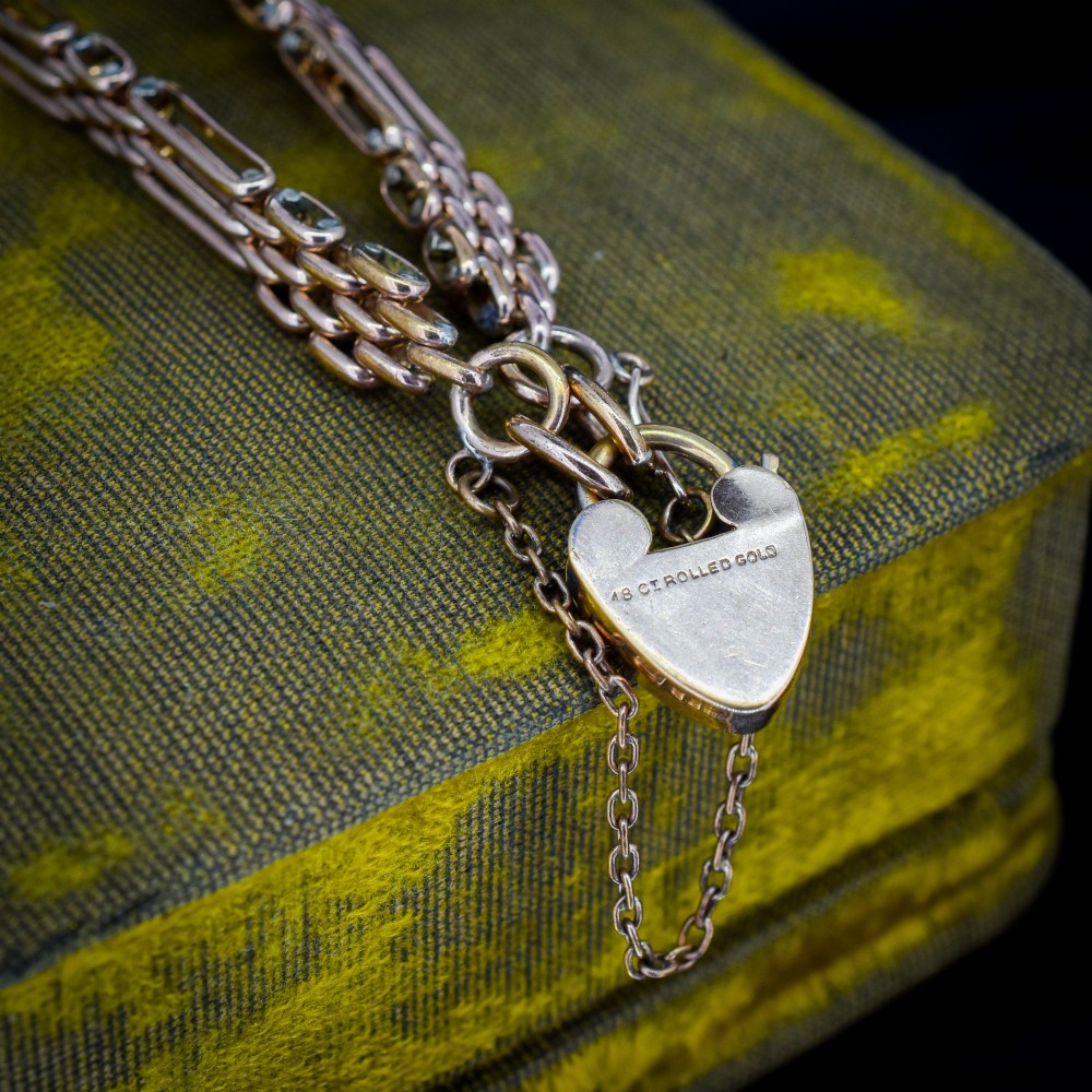 An antique rolled gold gate link bracelet featuring an engraved heart-shaped padlock clasp and safety chain. View V