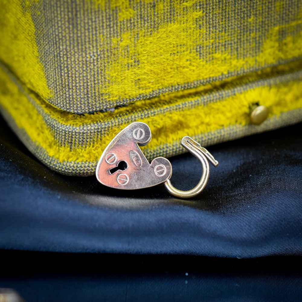 An antique rolled gold gate link bracelet featuring an engraved heart-shaped padlock clasp and safety chain. View VI