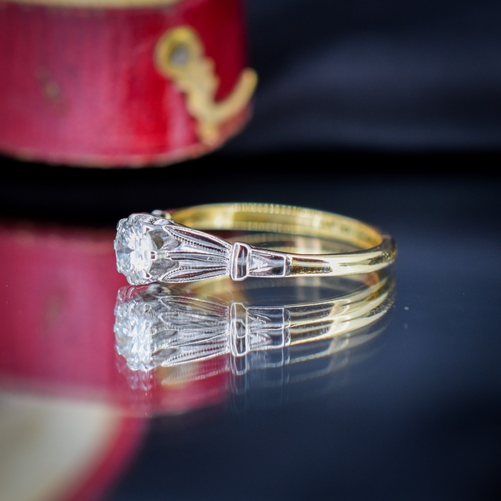 An Art Deco diamond solitaire ring featuring a round cut diamond set between detailed, fan-etched shoulders on an 18ct yellow gold band. View VII