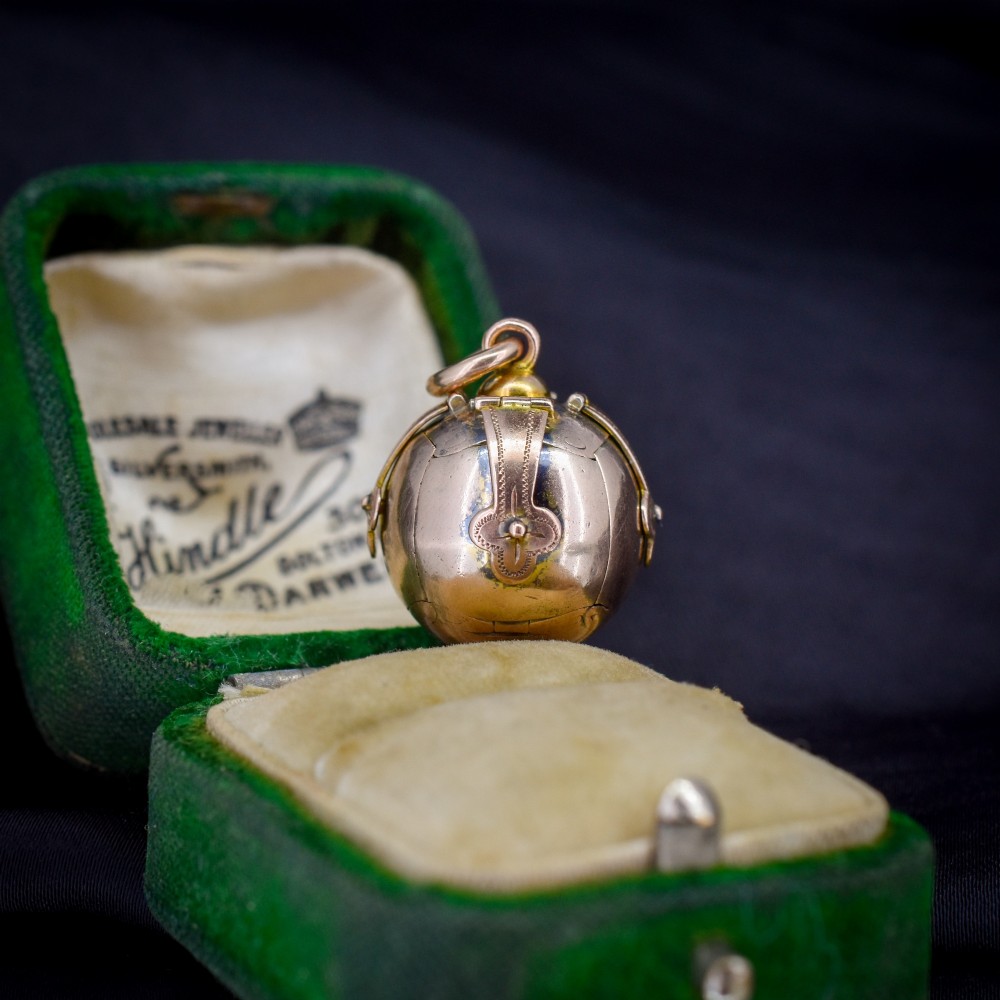 An antique spherical gold and silver Masonic ball charm featuring four chased outer arms and a top bail for suspension.