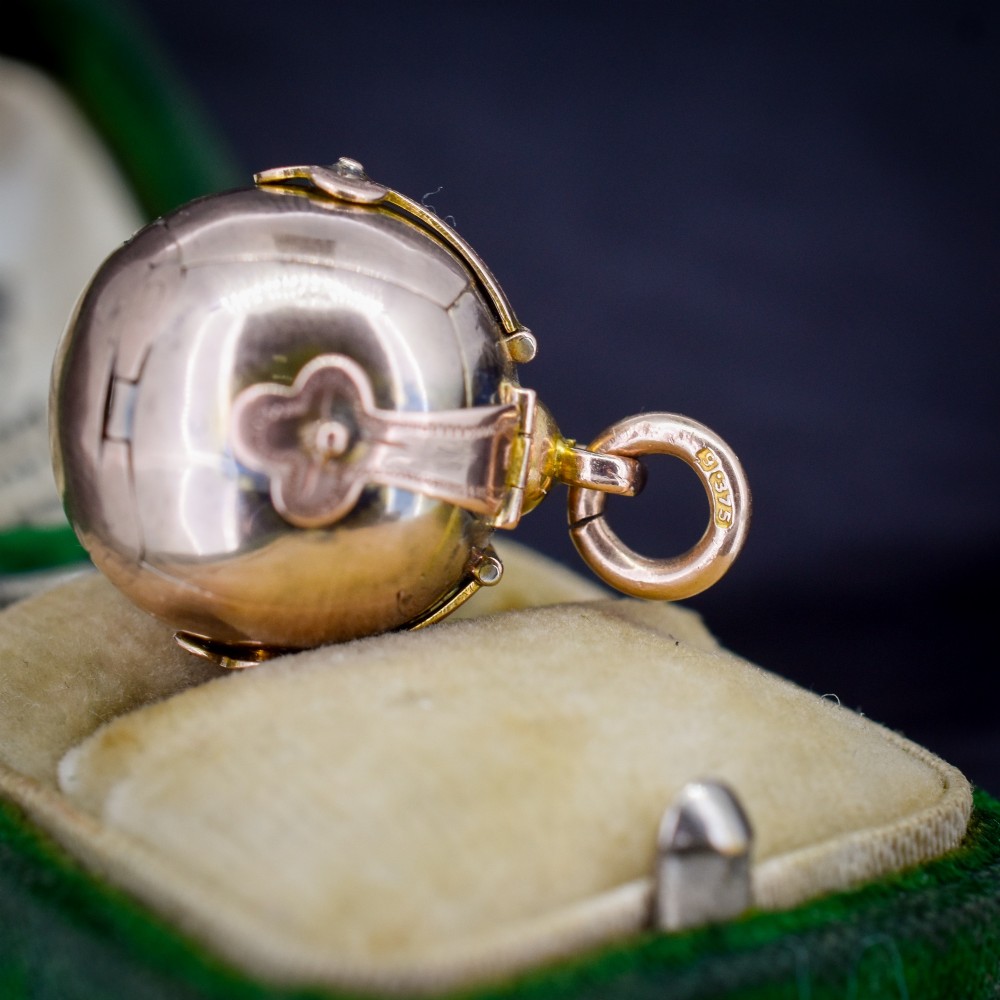 An antique spherical gold and silver Masonic ball charm featuring four chased outer arms and a top bail for suspension. View VII