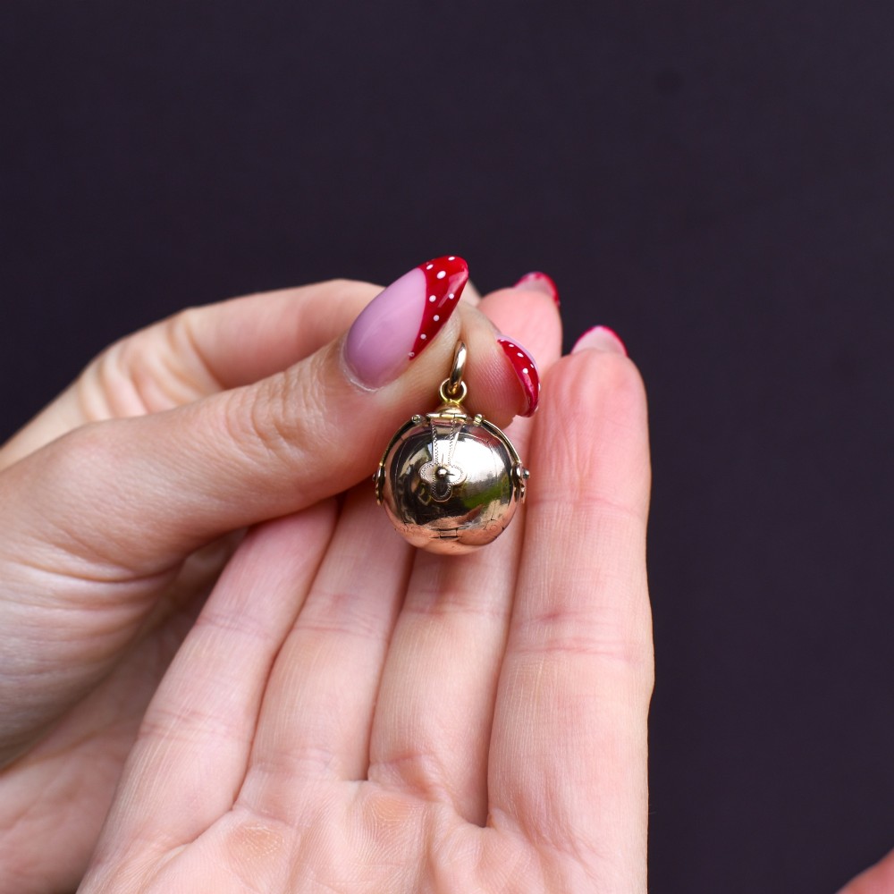 An antique spherical gold and silver Masonic ball charm featuring four chased outer arms and a top bail for suspension. View VIII