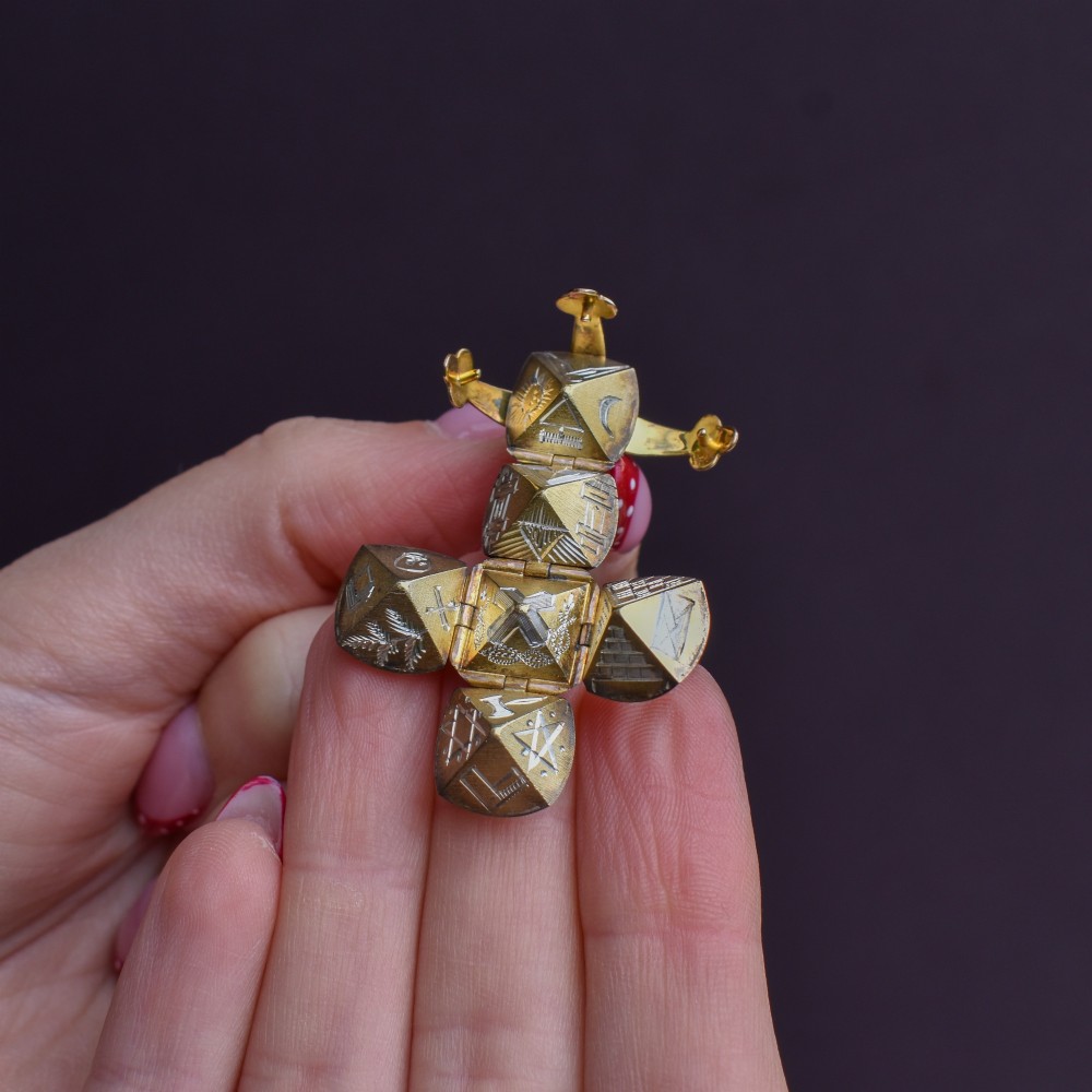 An antique spherical gold and silver Masonic ball charm featuring four chased outer arms and a top bail for suspension. View IX