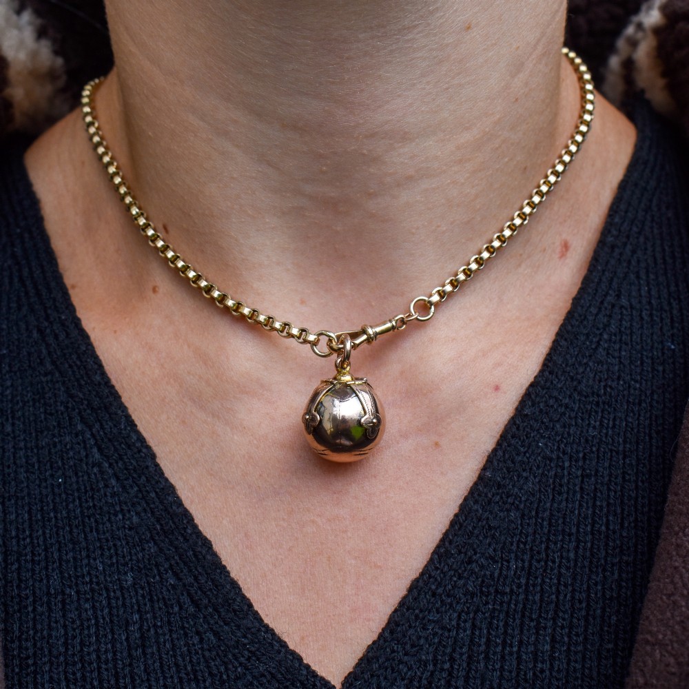 An antique spherical gold and silver Masonic ball charm featuring four chased outer arms and a top bail for suspension. View XI