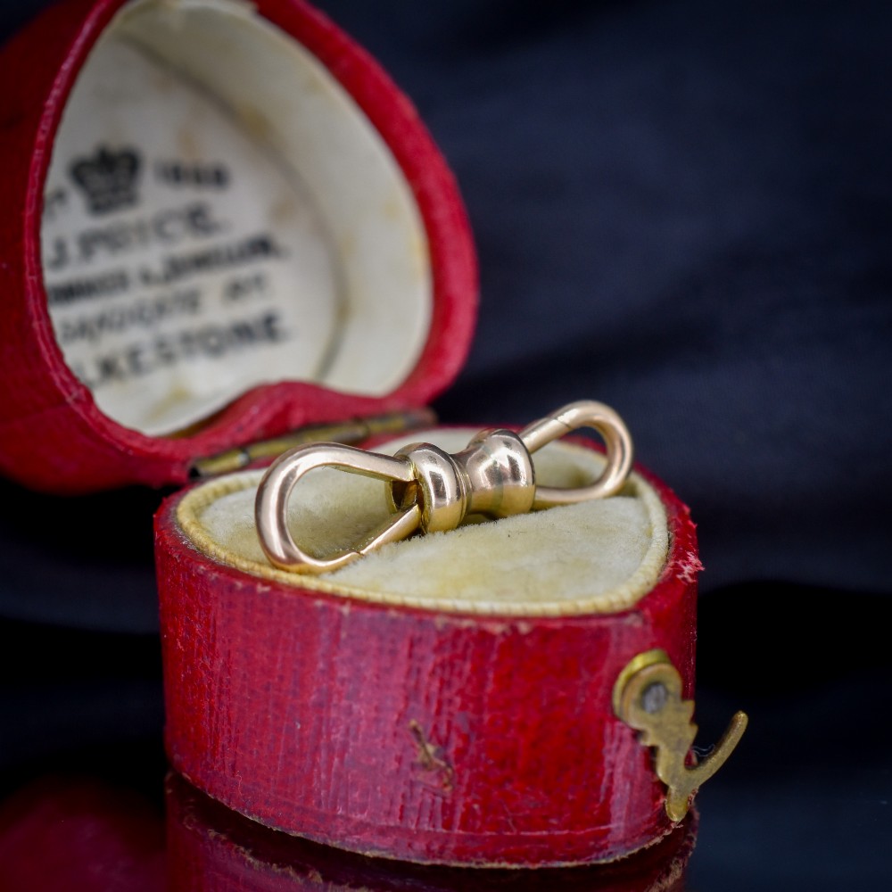 A double-sided 9ct yellow gold antique dog clip clasp featuring hinged spring fasteners at both ends connected by a central barrel collar. View II