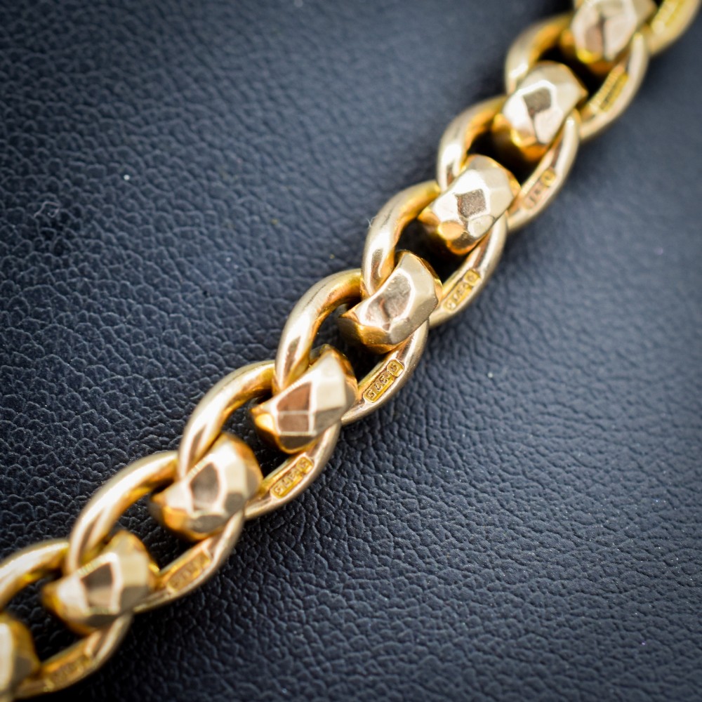 An antique 9ct yellow gold rollerball Albert chain featuring a central T-bar drop and double dog clip clasps. View V
