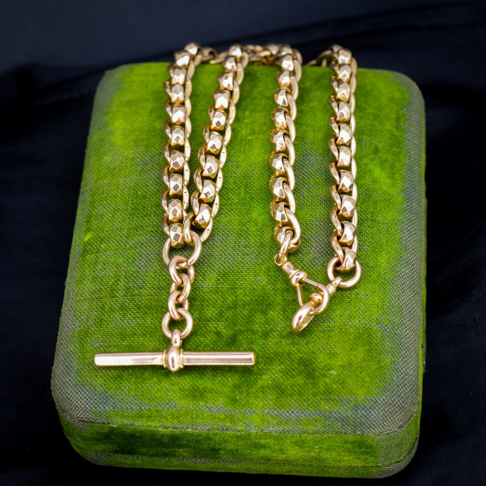 An antique 9ct yellow gold rollerball Albert chain featuring a central T-bar drop and double dog clip clasps.