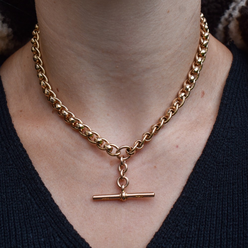 An antique 9ct yellow gold rollerball Albert chain featuring a central T-bar drop and double dog clip clasps. View X