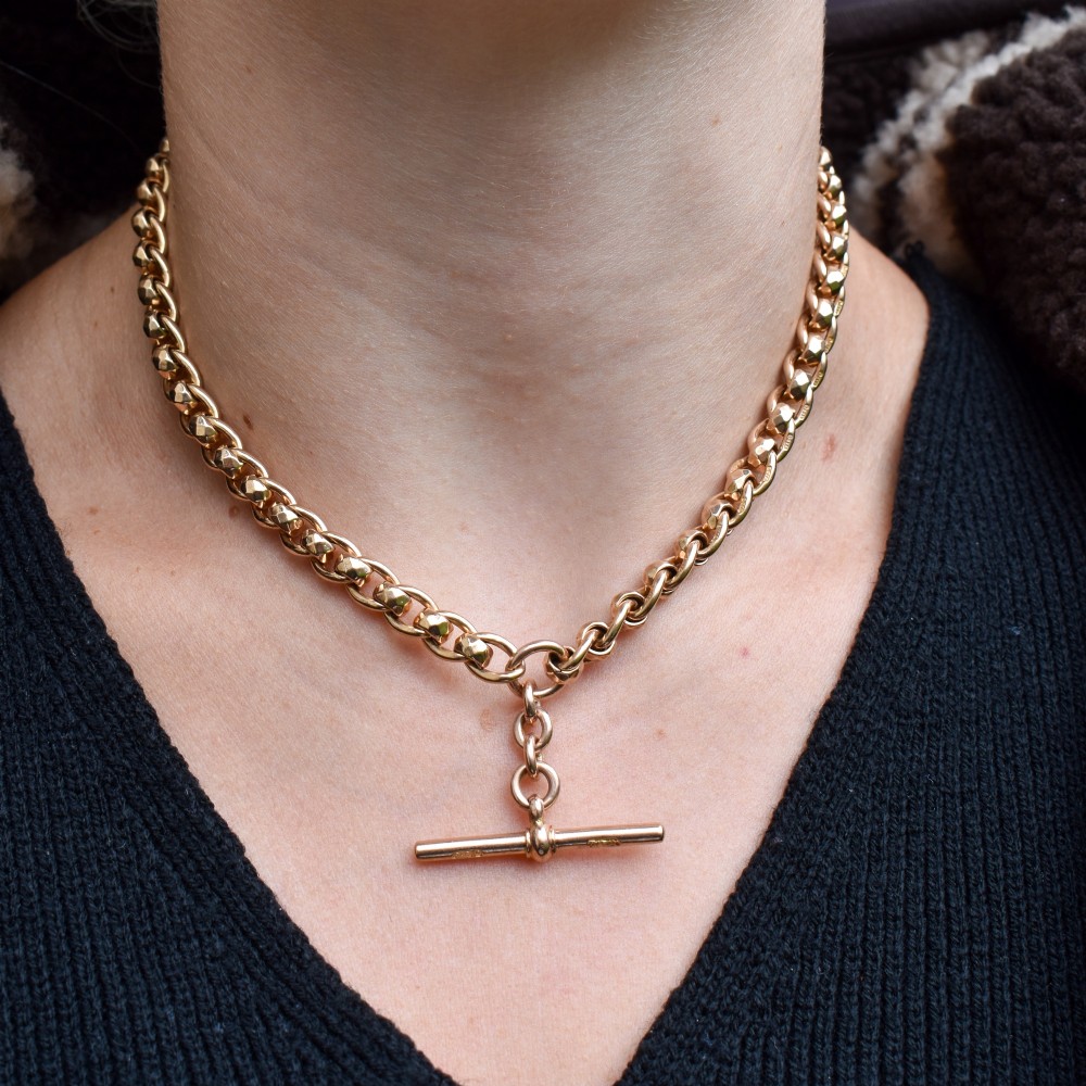 An antique 9ct yellow gold rollerball Albert chain featuring a central T-bar drop and double dog clip clasps. View XI