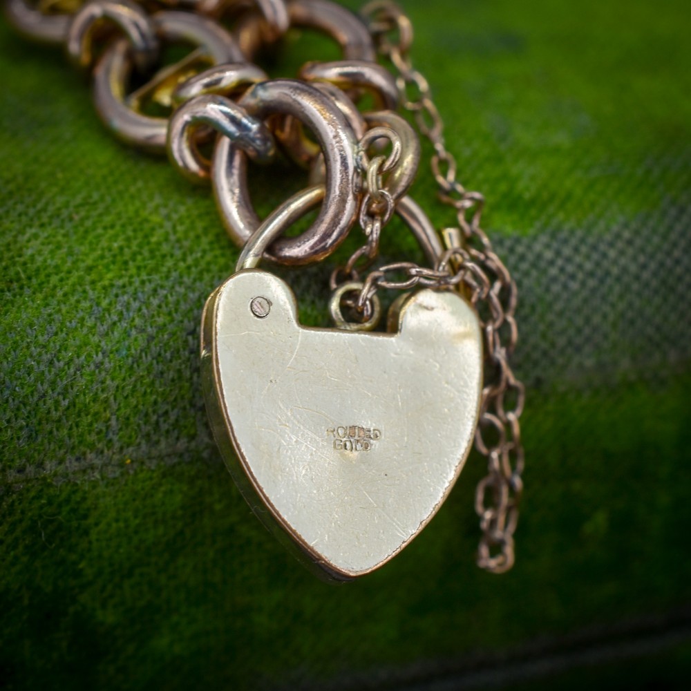 An antique rolled gold chain bracelet inset with alternating seed pearls and turquoise cabochons, featuring a heart-shaped padlock clasp with safety chain. View IV
