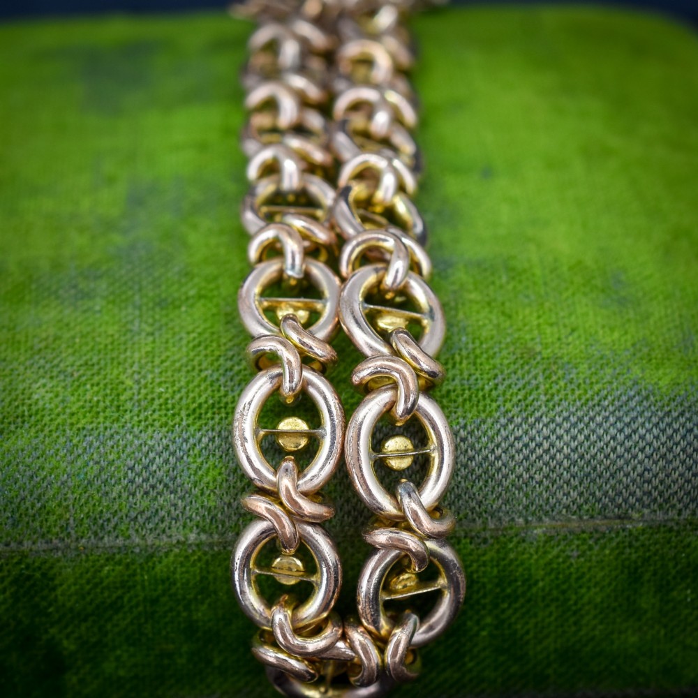 An antique rolled gold chain bracelet inset with alternating seed pearls and turquoise cabochons, featuring a heart-shaped padlock clasp with safety chain. View VI
