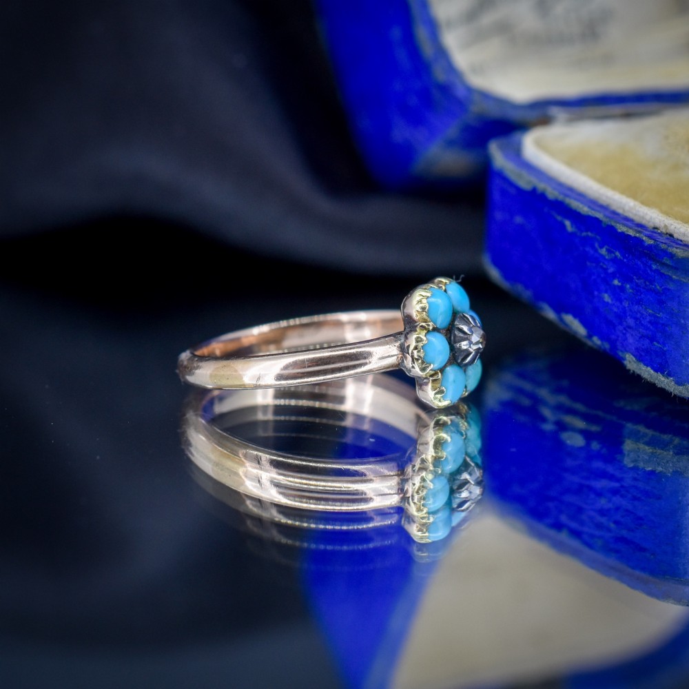 An antique 15ct yellow gold ring featuring a central diamond surrounded by six turquoise cabochons forming a floral cluster. View VII
