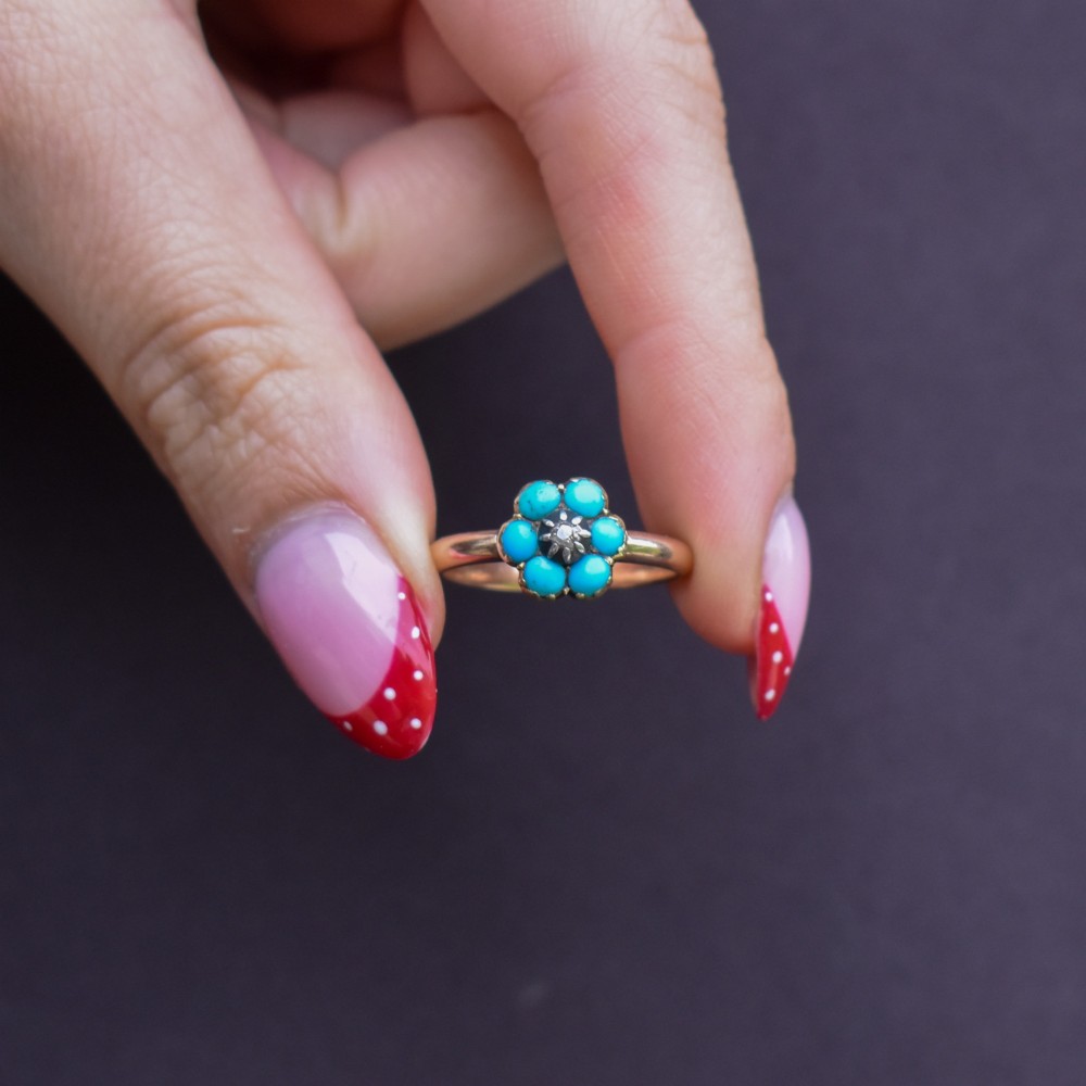 An antique 15ct yellow gold ring featuring a central diamond surrounded by six turquoise cabochons forming a floral cluster. View VIII