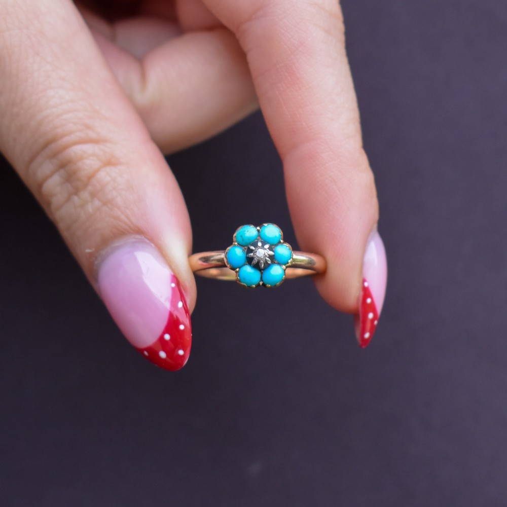 An antique 15ct yellow gold ring featuring a central diamond surrounded by six turquoise cabochons forming a floral cluster. View IX