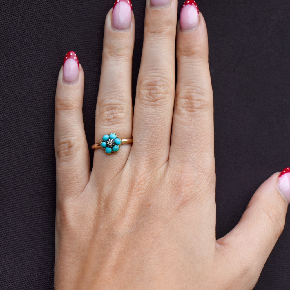 An antique 15ct yellow gold ring featuring a central diamond surrounded by six turquoise cabochons forming a floral cluster. View XI