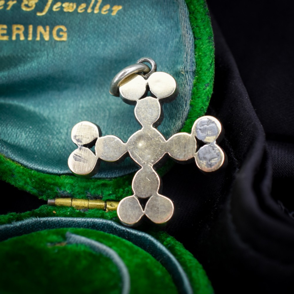 A Georgian silver bottony cross pendant set with clear faceted paste stones featuring black dot culets. View IV