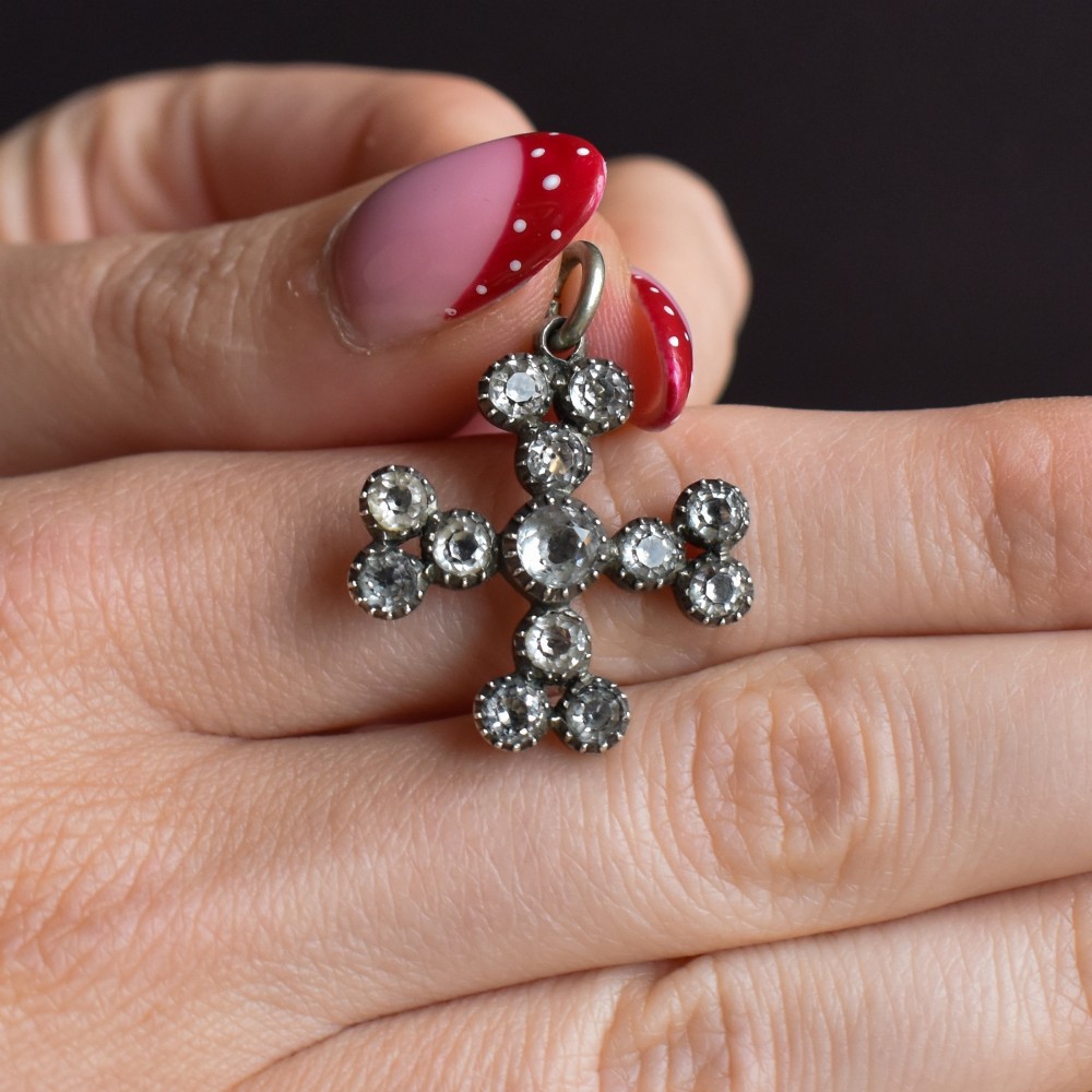 A Georgian silver bottony cross pendant set with clear faceted paste stones featuring black dot culets. View VI