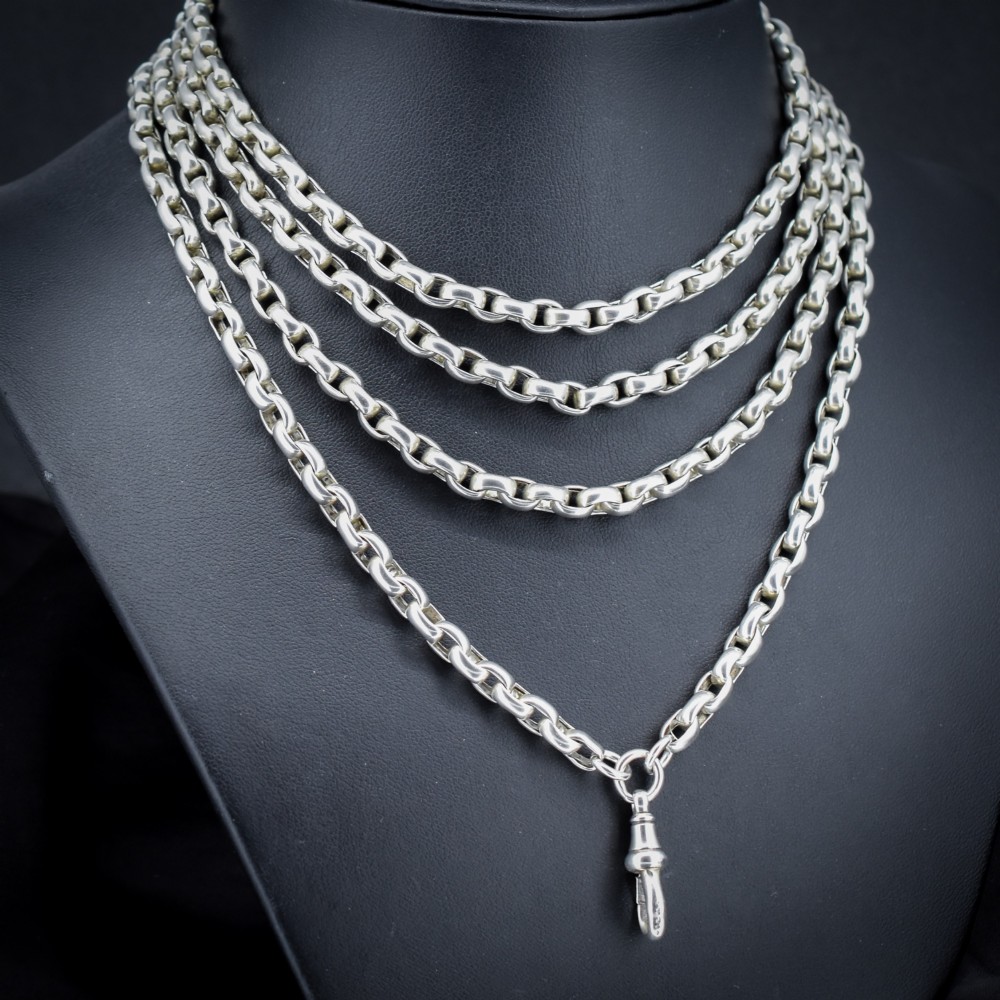 An antique sterling silver long guard chain featuring belcher links and a dog clip clasp, wrapped in multiple layers on a display bust. View II