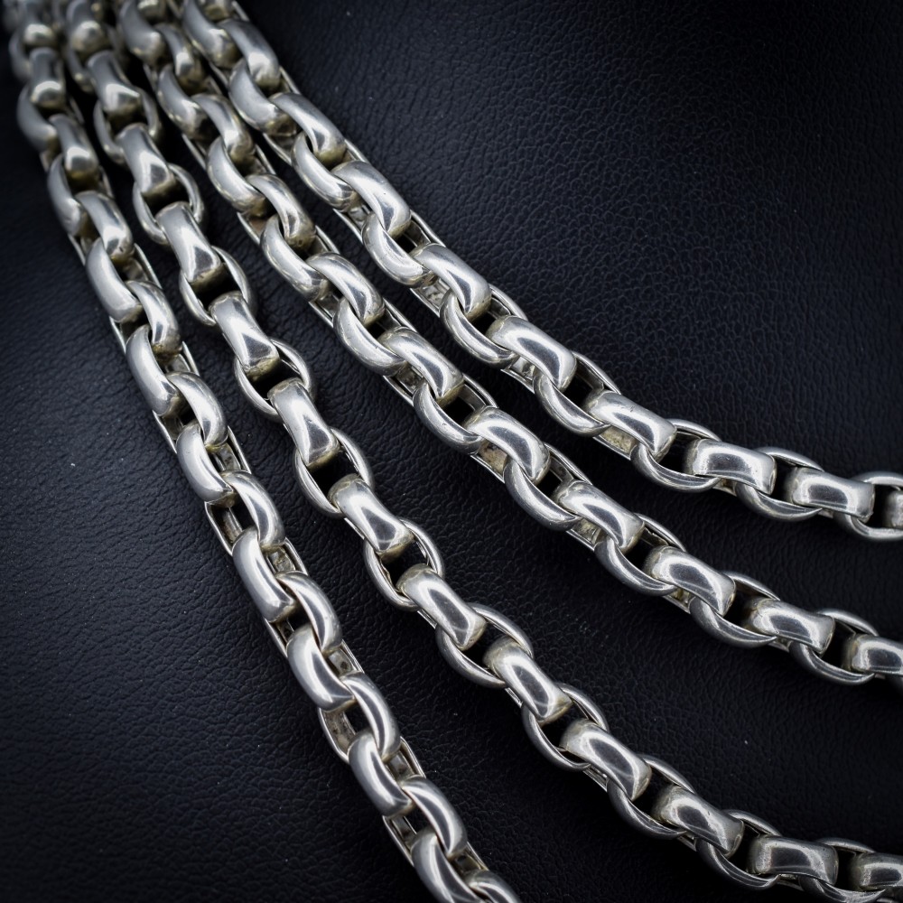 An antique sterling silver long guard chain featuring belcher links and a dog clip clasp, wrapped in multiple layers on a display bust. View III