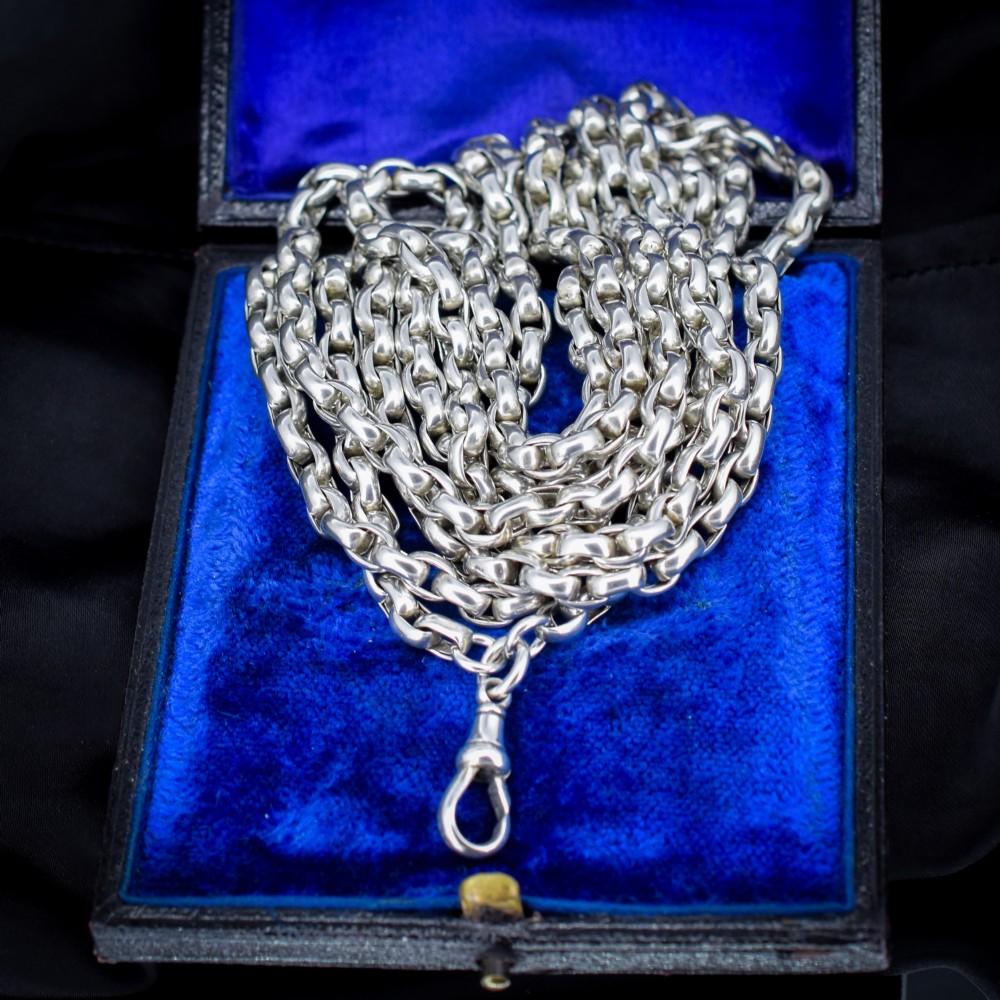 An antique sterling silver long guard chain featuring belcher links and a dog clip clasp, wrapped in multiple layers on a display bust. View VI