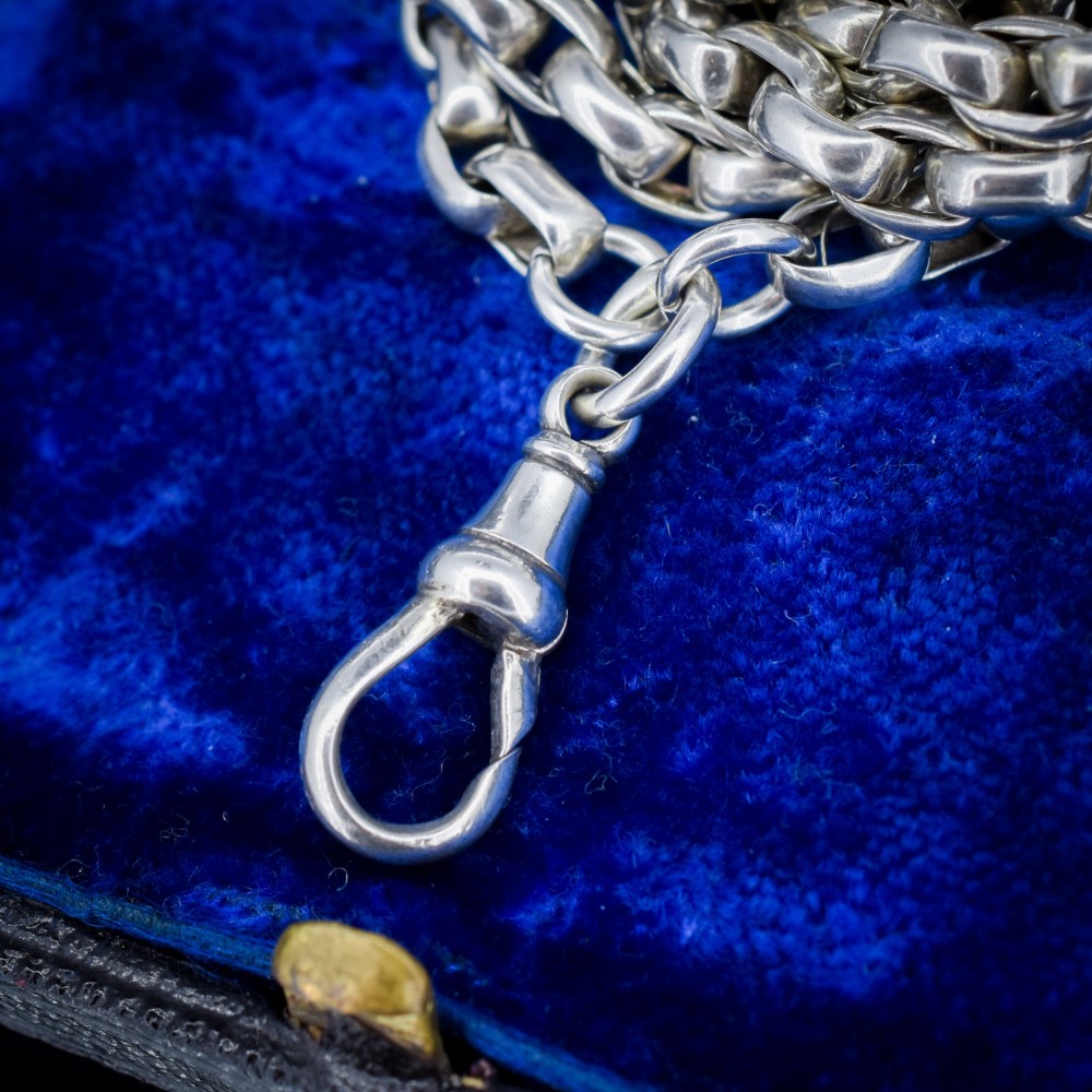 An antique sterling silver long guard chain featuring belcher links and a dog clip clasp, wrapped in multiple layers on a display bust. View VII