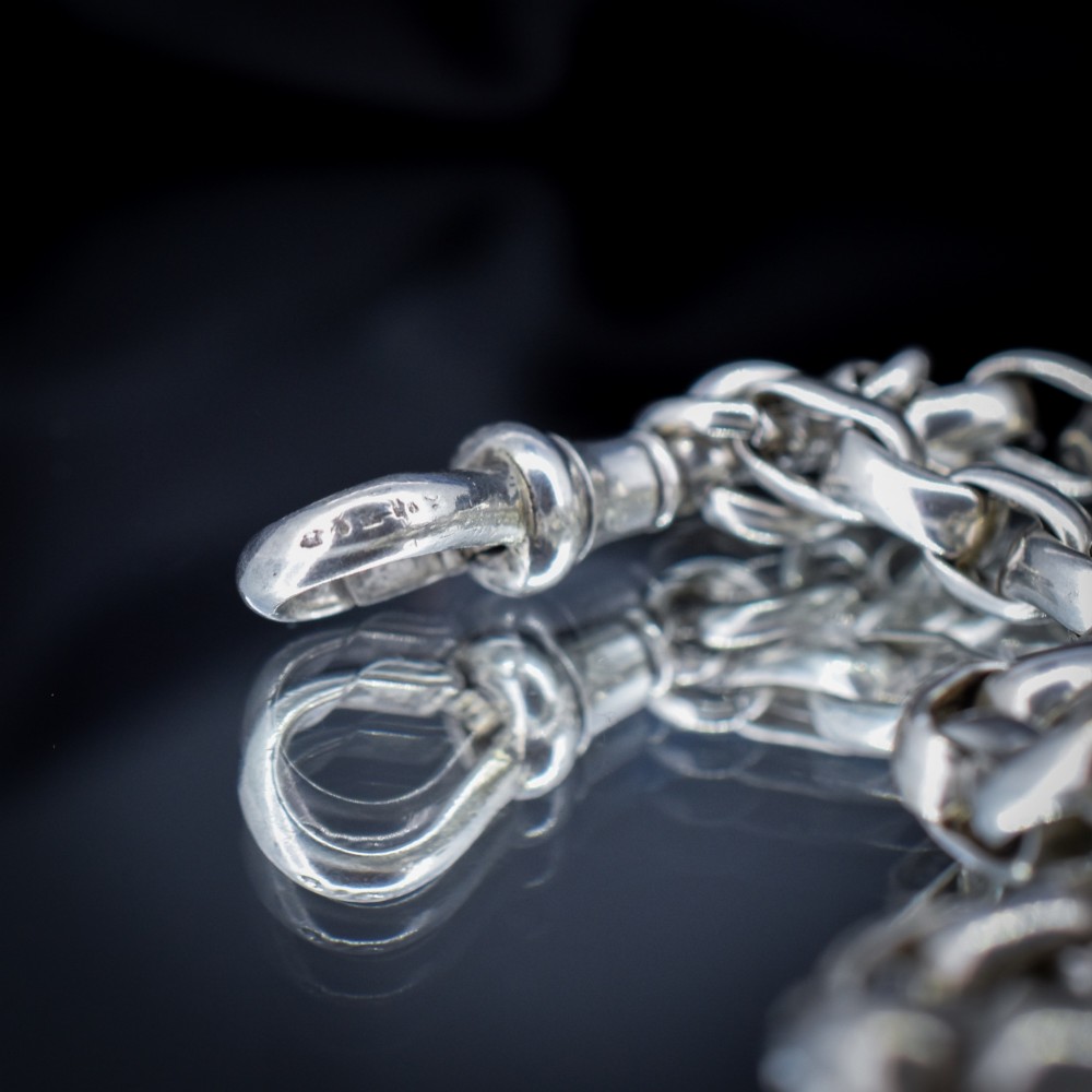 An antique sterling silver long guard chain featuring belcher links and a dog clip clasp, wrapped in multiple layers on a display bust. View VIII