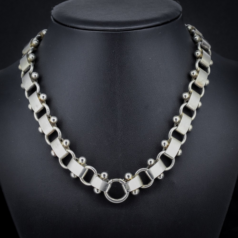 An antique Victorian sterling silver collar necklace featuring wide engraved rectangular links accented with silver beads and linked by circular rings. View IV