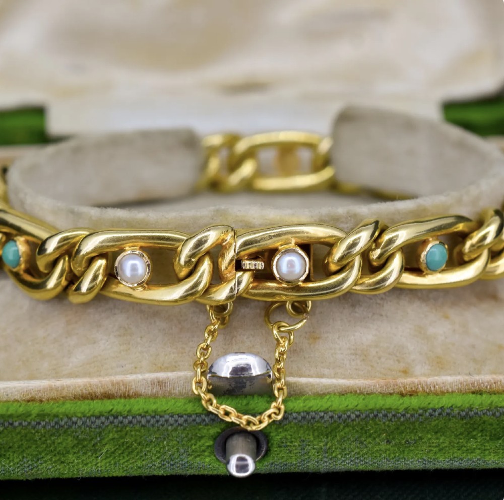 An antique 15ct yellow gold curb link bracelet inset with alternating pearls and cabochon turquoise stones, featuring a fitted safety chain. View IV