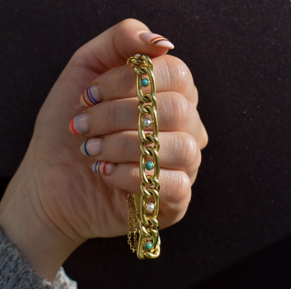 An antique 15ct yellow gold curb link bracelet inset with alternating pearls and cabochon turquoise stones, featuring a fitted safety chain. View V