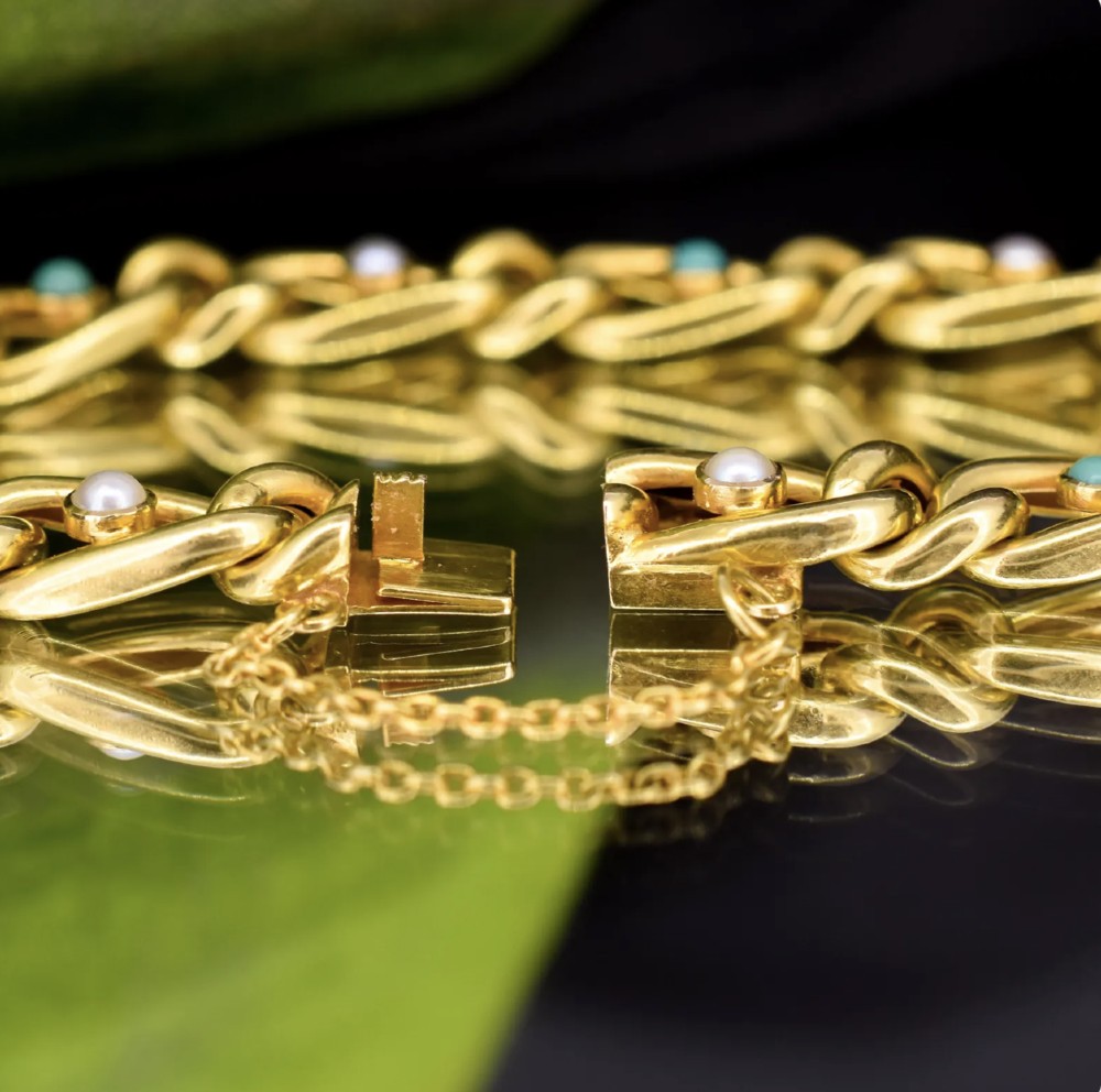 An antique 15ct yellow gold curb link bracelet inset with alternating pearls and cabochon turquoise stones, featuring a fitted safety chain. View IX