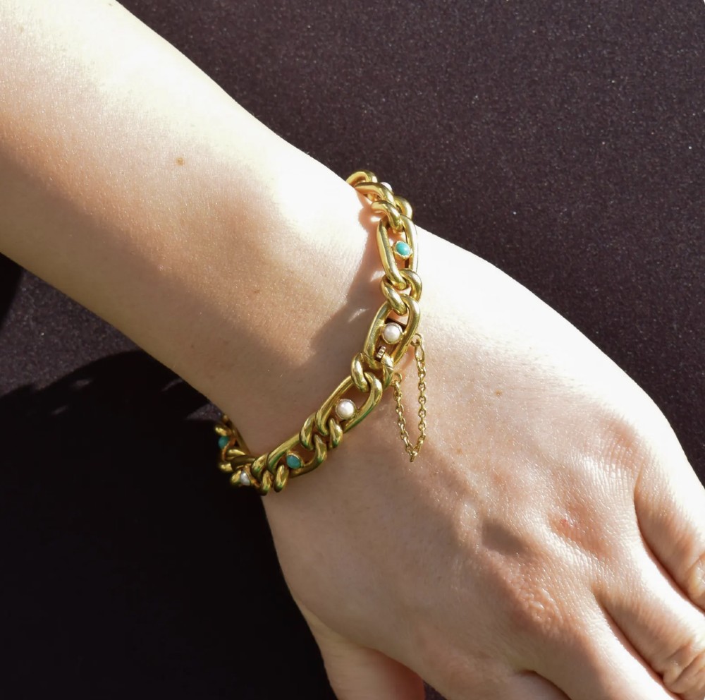 An antique 15ct yellow gold curb link bracelet inset with alternating pearls and cabochon turquoise stones, featuring a fitted safety chain. View XI