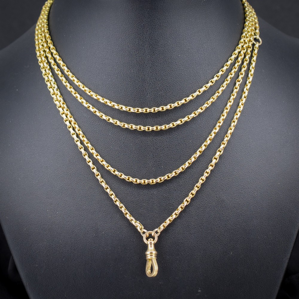 An antique 10ct yellow gold long guard chain featuring faceted oval links and a dog clip fastener. View II