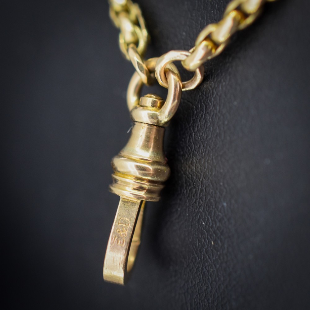 An antique 10ct yellow gold long guard chain featuring faceted oval links and a dog clip fastener. View VI