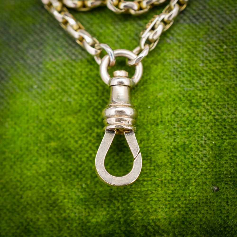 An antique 10ct yellow gold long guard chain featuring faceted oval links and a dog clip fastener. View VII