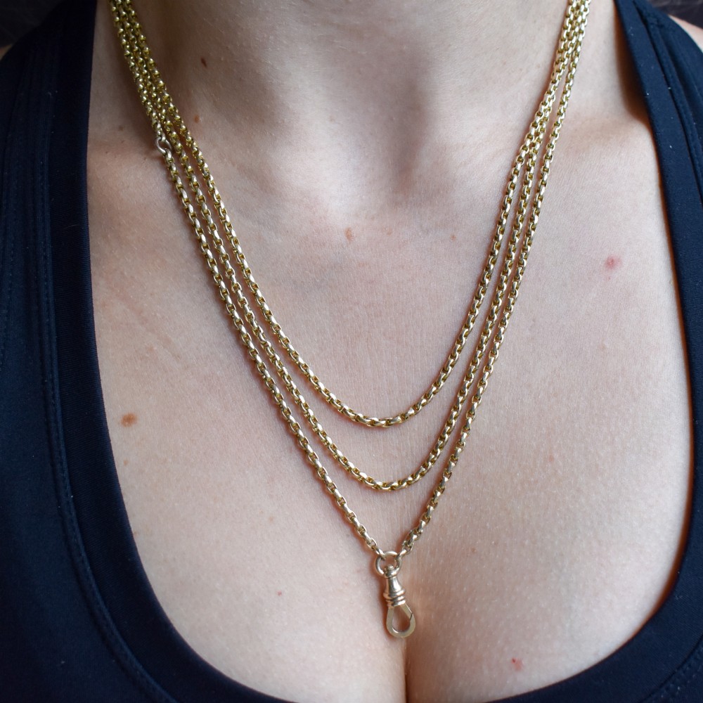 An antique 10ct yellow gold long guard chain featuring faceted oval links and a dog clip fastener. View IX