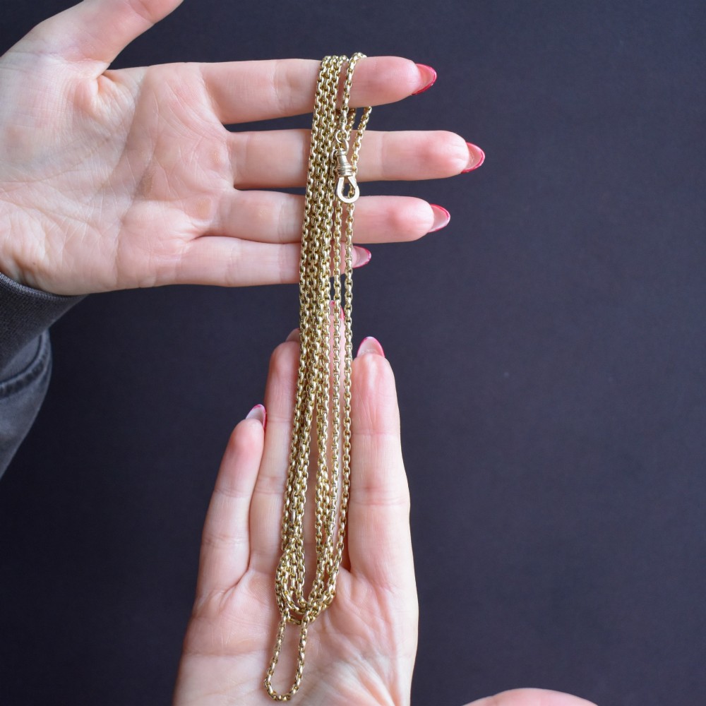 An antique 10ct yellow gold long guard chain featuring faceted oval links and a dog clip fastener. View XI
